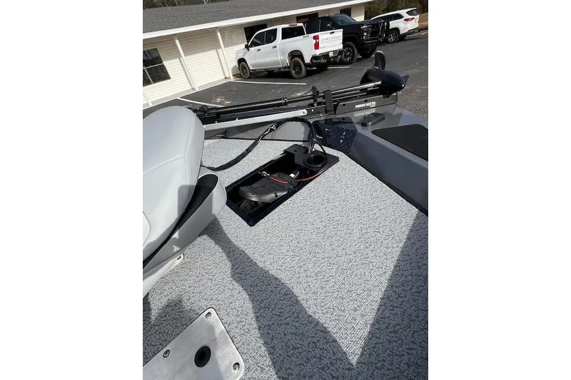 Slide: The Image of 2026 G3 Sportsman 1710 SE boat deck with trolling motor and seat, parked near vehicles. - 3
