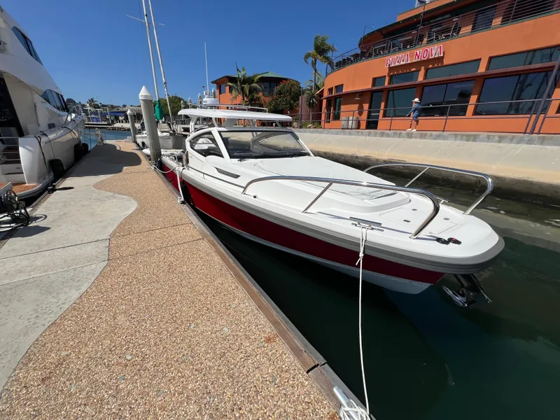 Slide: The Image of 2024 Nimbus W9 boat docked at a marina with modern architecture. - 1