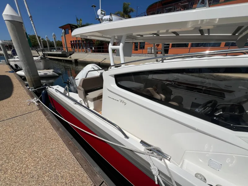 Slide: The Image of 2024 Nimbus W9 boat docked at marina under clear blue sky. - 2