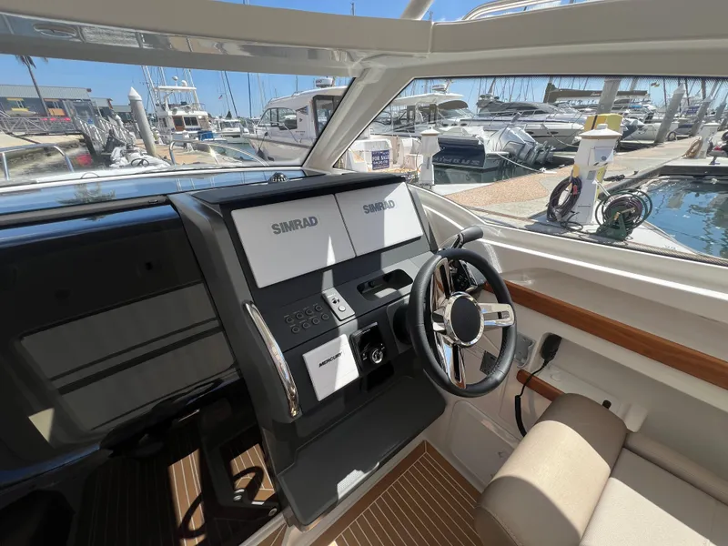 Slide: The Image of 2024 Nimbus W9 boat cockpit with Simrad navigation system, docked at marina. - 5