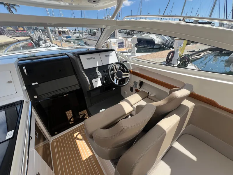 Slide: The Image of 2024 Nimbus W9 boat interior with modern dashboard and comfortable seating at marina. - 6