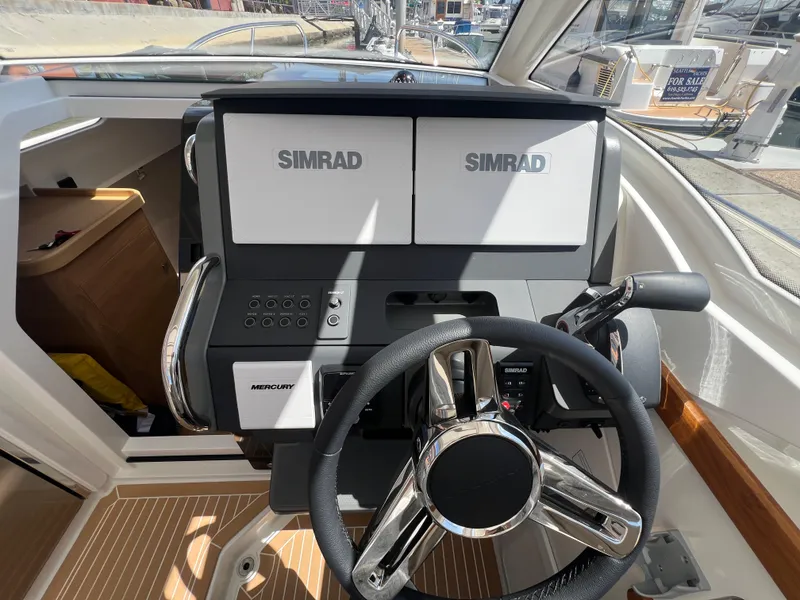 Slide: The Image of 2024 Nimbus W9 boat dashboard with Simrad displays and Mercury controls. - 8