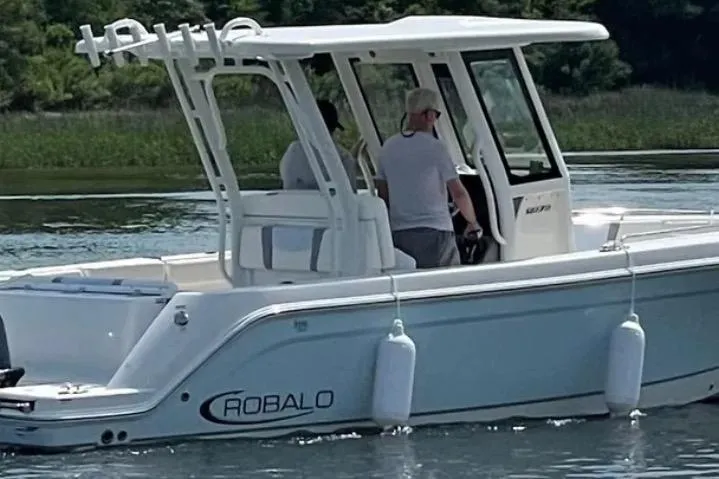 The Image of 2022 Robalo R272 Center Console boat cruising on a scenic waterway. - 0