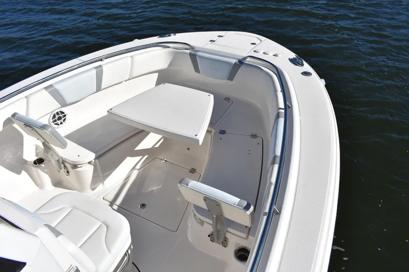 Slide: The Image of 2022 Robalo R272 Center Console boat interior with seating and table on water. - 10