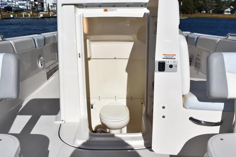 Slide: The Image of 2022 Robalo R272 Center Console boat with open marine toilet compartment. - 13