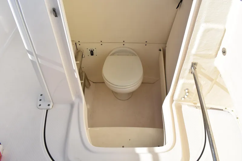Slide: The Image of 2022 Robalo R272 Center Console boat interior with compact marine toilet. - 15