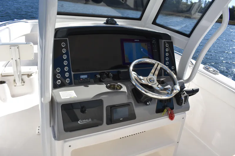 Slide: The Image of 2022 Robalo R272 Center Console boat dashboard with steering wheel and navigation display. - 18