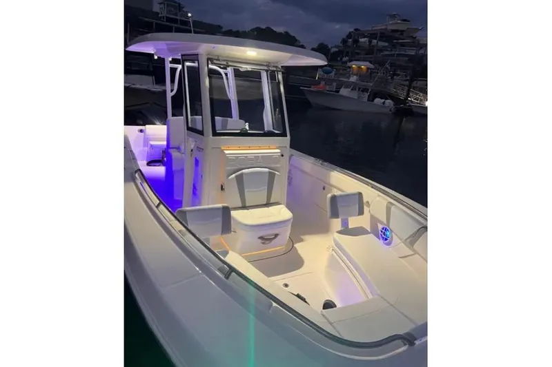 Slide: The Image of 2022 Robalo R272 Center Console boat on water, with Yamaha engine, near shoreline houses. - 2