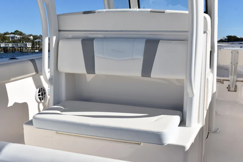 Slide: The Image of 2022 Robalo R272 Center Console boat seating area with white cushioned seats. - 25