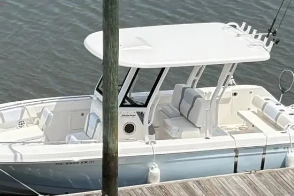 Slide: The Image of 2022 Robalo R272 Center Console boat with dual 250 V6 engines on water. - 3