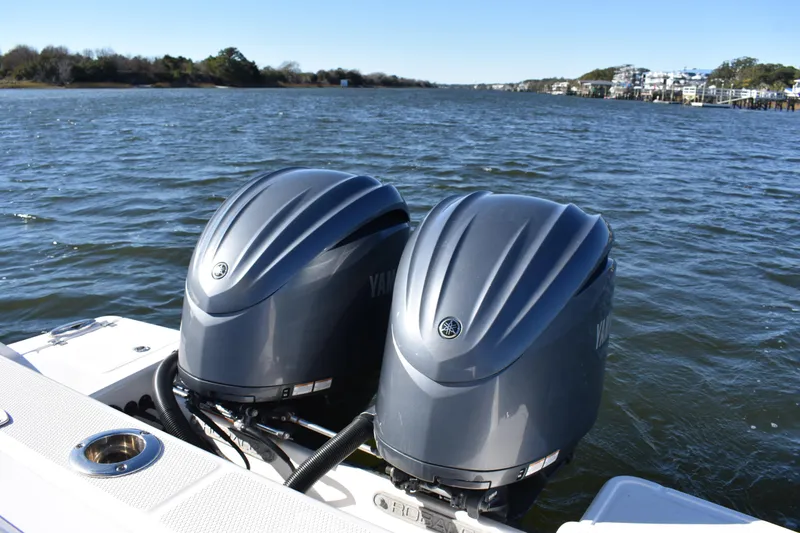 Slide: The Image of 2022 Robalo R272 Center Console with dual Yamaha outboard engines on a scenic waterway. - 30
