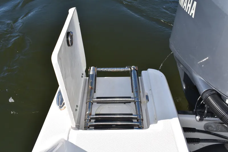 Slide: The Image of 2022 Robalo R272 Center Console boat with a folded swim ladder and Yamaha engine. - 31