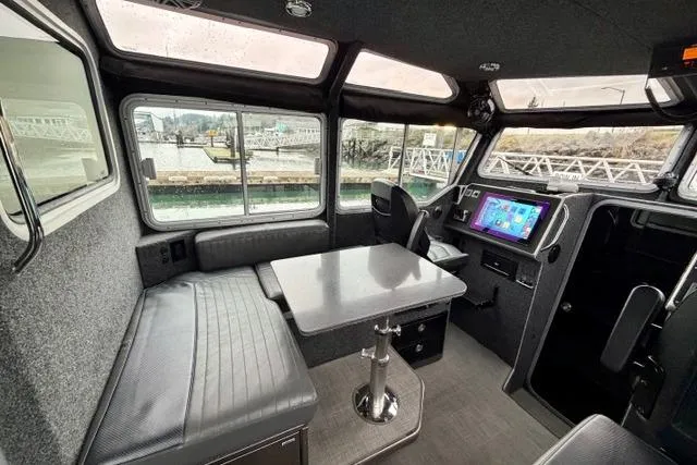 Slide: The Image of Interior of a 2017 Life Proof 33 boat with seating, table, and control panel. - 20