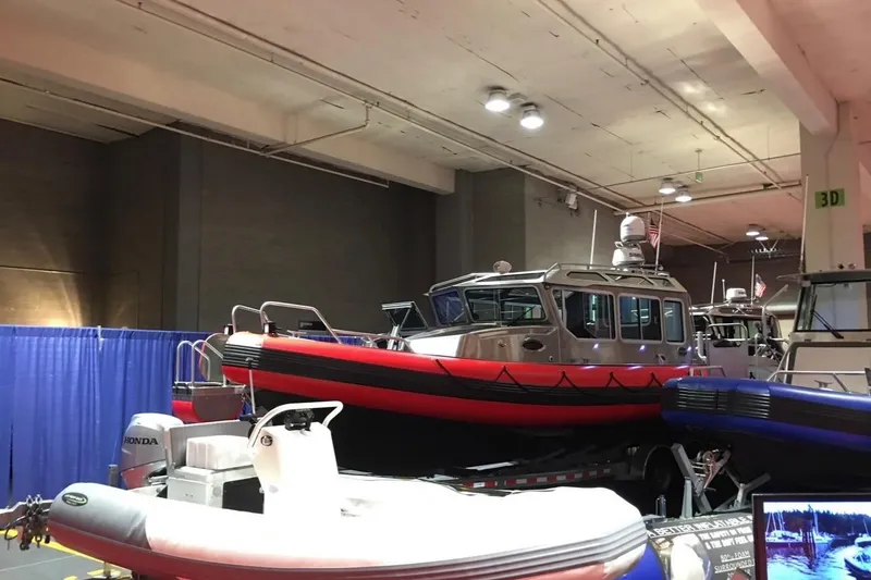 Slide: The Image of Indoor display of Lifeproof 33 boats, 2017 model, featuring vibrant red and blue designs. - 5