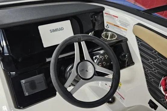 Slide: The Image of 2026 Sea Ray SPX 210 Outboard dashboard with steering wheel and Simrad display. - 2