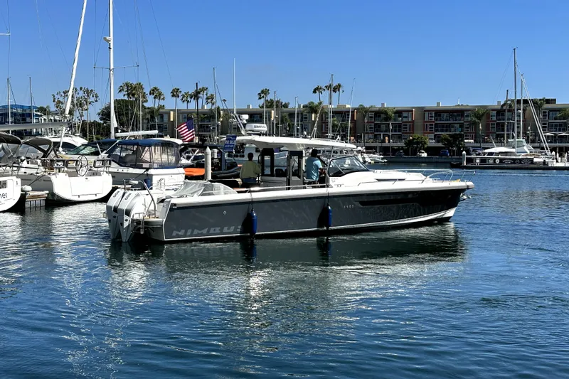 The Image of 2023 Nimbus T11 boat docked in a marina with clear blue skies. - 0