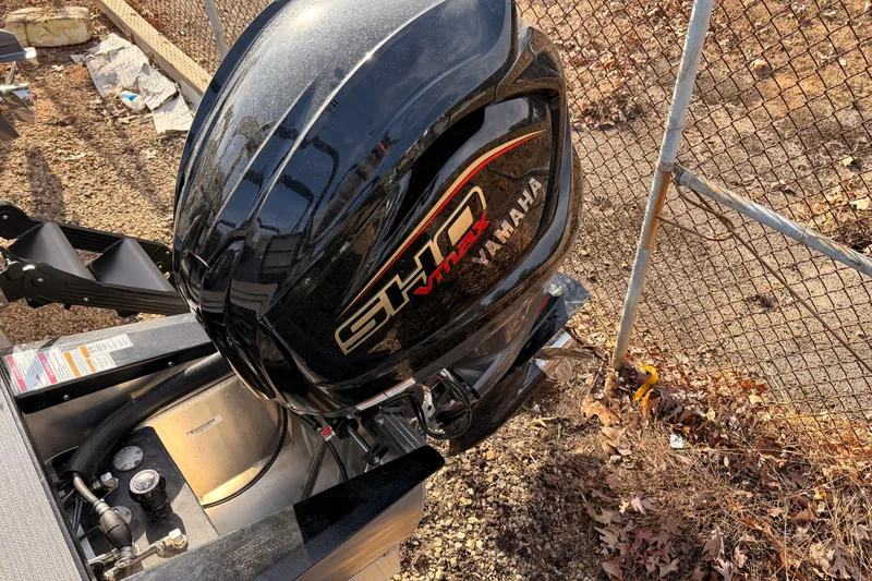 Slide: The Image of 2026 Veranda Vista Sport VS 25 RC with Yamaha outboard motor, parked near a chain-link fence. - 12