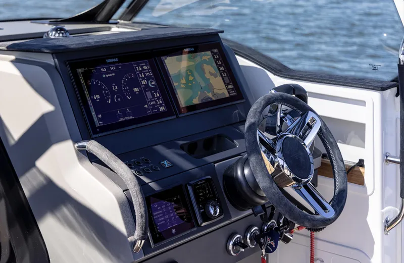 Slide: The Image of Control panel of Nimbus T9 #103 Twin Engine 2023 boat with navigation screens and steering wheel. - 9