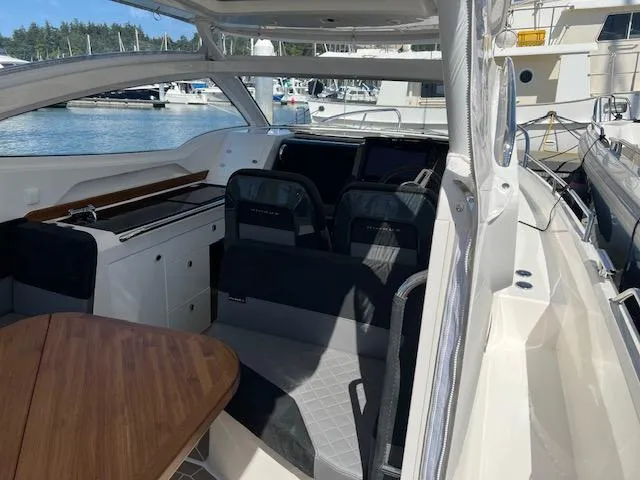 Slide: The Image of Interior of 2023 Nimbus W9 boat with seating and wooden table, docked at marina. - 24