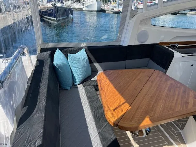 Slide: The Image of Luxurious 2023 Nimbus W9 yacht interior with cozy seating and wooden table. - 26