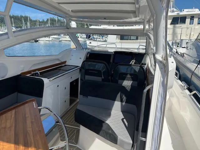 Slide: The Image of Interior of 2023 Nimbus W9 boat with seating and navigation area, docked at marina. - 28