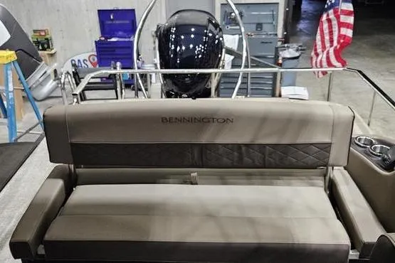 Slide: The Image of 2026 Bennington 24 L Swingback boat interior with seating and American flag in background. - 13