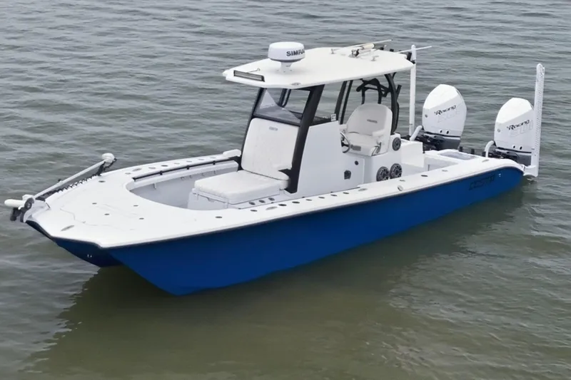 Slide: The Image of 2023 Costa Custom Boats 264 HC, blue and white, on calm water. - 6