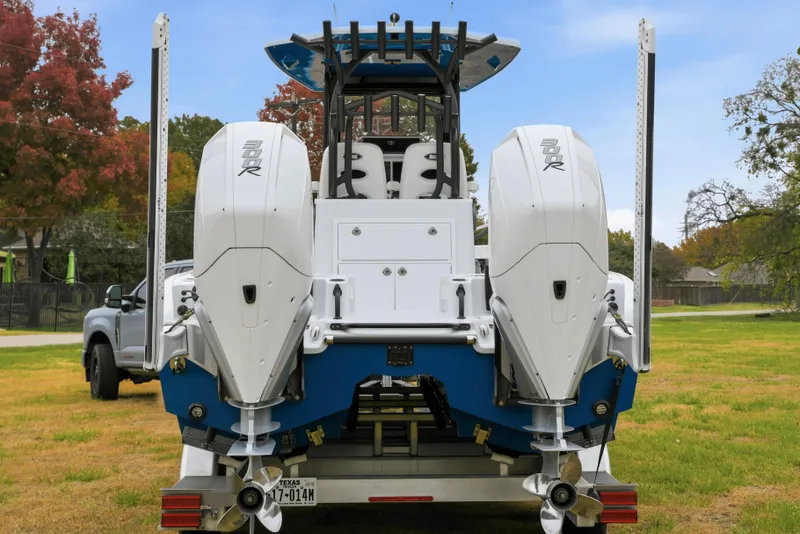 Slide: The Image of 2023 Costa Custom Boats 264 HC with dual outboard engines on a grassy field. - 8