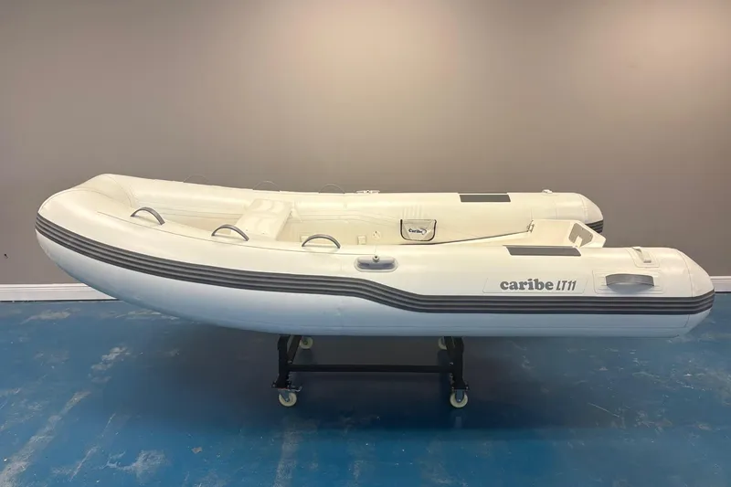 The Image of Inflatable Caribe L-11 boat with Mercury 20MH motor, displayed indoors, 2025 model. - 0