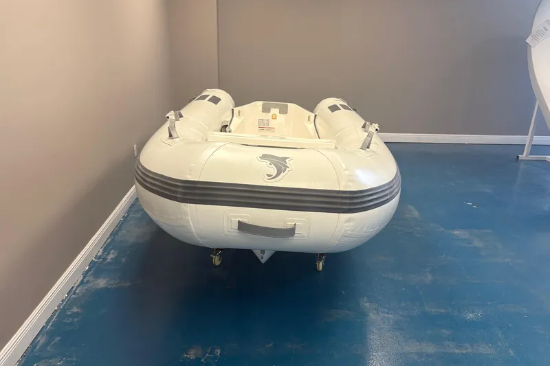 Slide: The Image of 2025 Caribe L-11 inflatable boat with Mercury 20MH motor displayed indoors. - 5