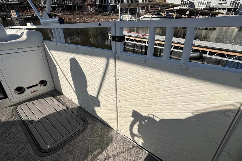 Slide: The Image of Interior of 2026 JC Sporttoon 26TT boat with quilted paneling and dock view. - 34