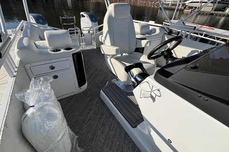 Slide: The Image of Interior of 2026 JC Sporttoon 26TT boat with white seating and steering console. - 43