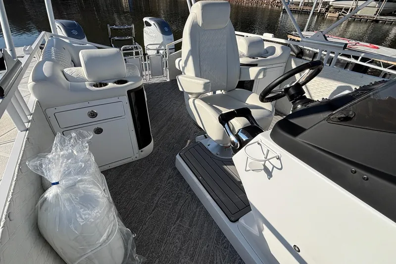 Slide: The Image of Interior of 2026 JC Sporttoon 26TT boat with white seating and steering console. - 44