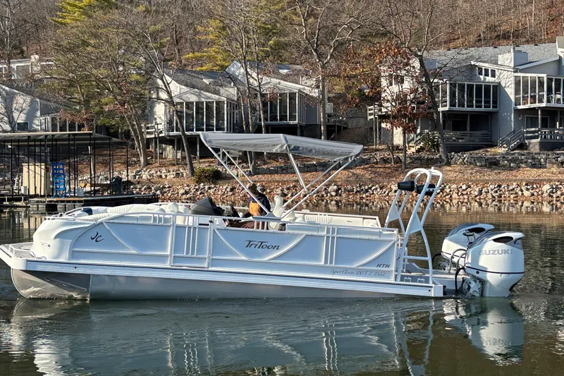Slide: The Image of Pontoon boat JC Sporttoon 26TT 2026 on a calm lake near modern lakeside homes. - 6