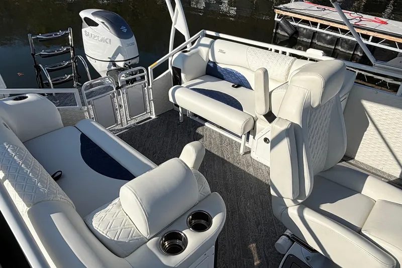 Slide: The Image of Luxurious 2026 JC Sporttoon 26TT pontoon boat interior with plush seating and Suzuki outboard motor. - 14