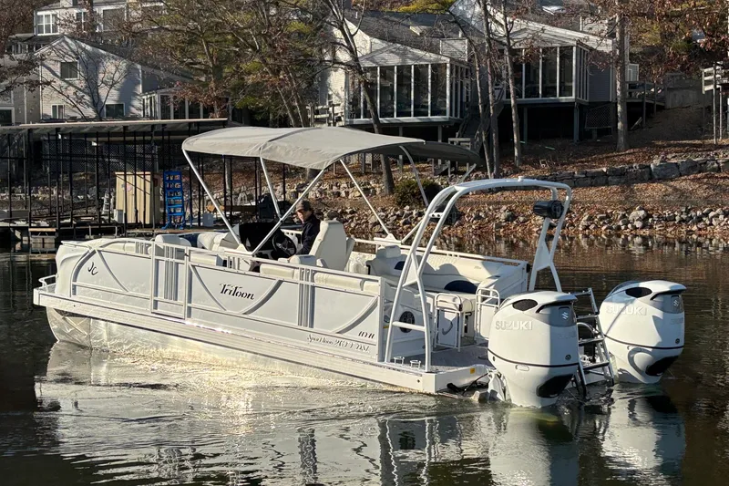 Slide: The Image of 2026 JC Sporttoon 26TT pontoon boat on a calm lake near waterfront homes. - 5