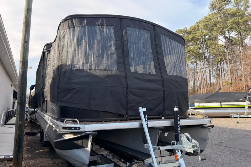 Slide: The Image of 2021 Premier 310 Boundary Waters Rev Top Deck pontoon boat with protective cover in a storage area. - 3