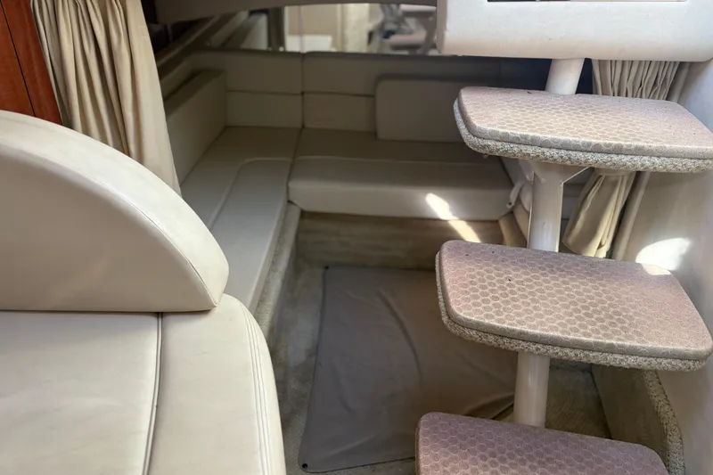 Slide: The Image of Interior of 2005 Sea Ray 300 Sundancer with beige seating and carpeted steps. - 10