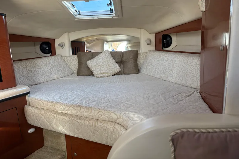 Slide: The Image of Interior cabin of 2005 Sea Ray 300 Sundancer with cozy bedding and elegant wood finish. - 11