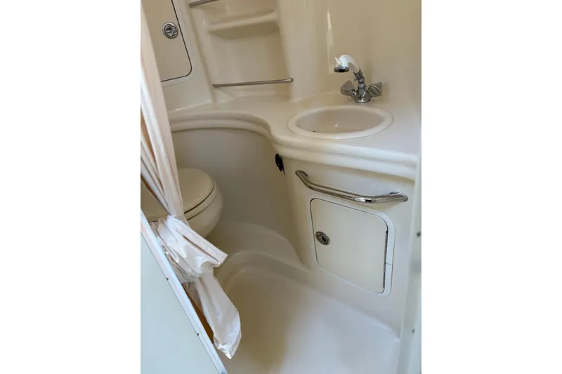 Slide: The Image of 2005 Sea Ray 300 Sundancer bathroom with sink, toilet, and storage cabinet. - 12