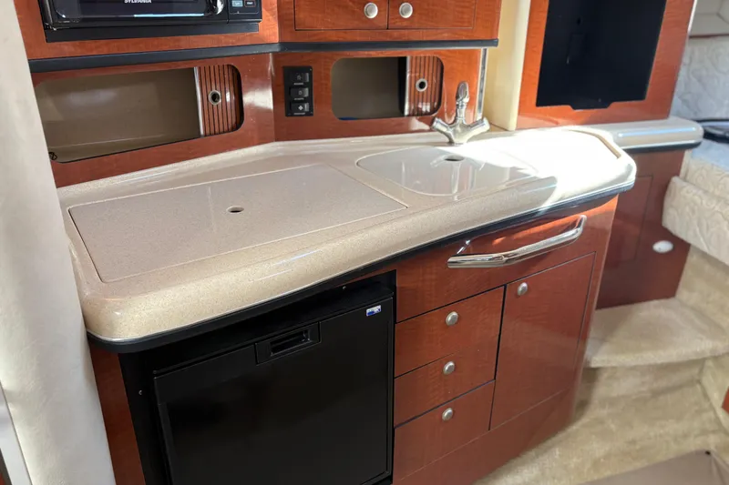 Slide: The Image of 2005 Sea Ray 300 Sundancer cabin kitchen with sink, storage, and microwave. - 13