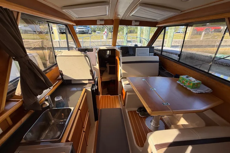 Slide: The Image of Interior of a 2015 Cutwater 28 boat with wooden finishes and seating area. - 17