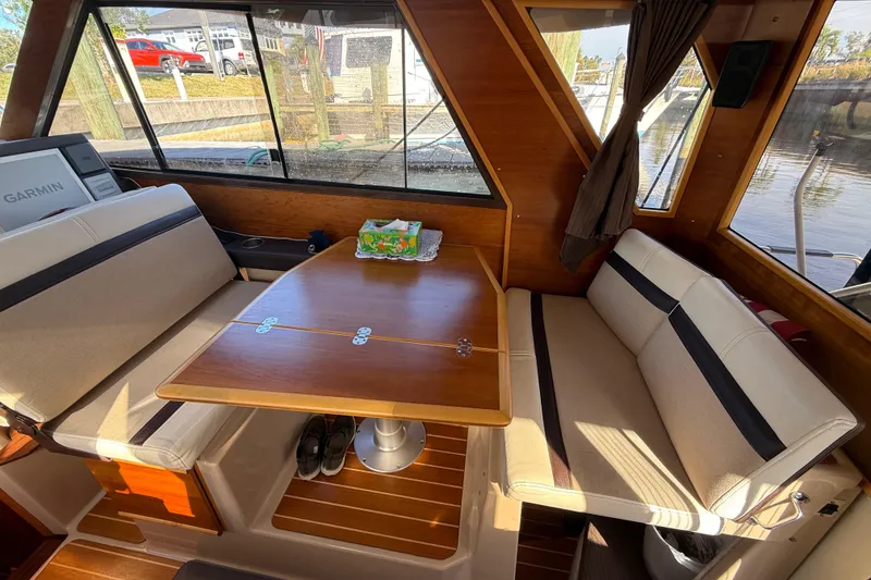 Slide: The Image of Interior of a 2015 Cutwater 28 boat with seating and a wooden table. - 19
