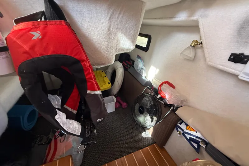 Slide: The Image of 2015 Cutwater 28 cabin interior with life jacket, fan, and storage items. - 27