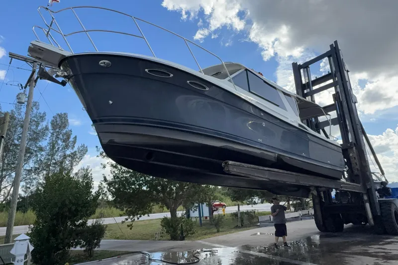 Slide: The Image of 2015 Cutwater 28 boat lifted by forklift under a cloudy sky. - 3