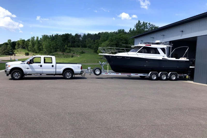 Slide: The Image of White truck towing 2015 Cutwater 28 boat on trailer near garage. - 30