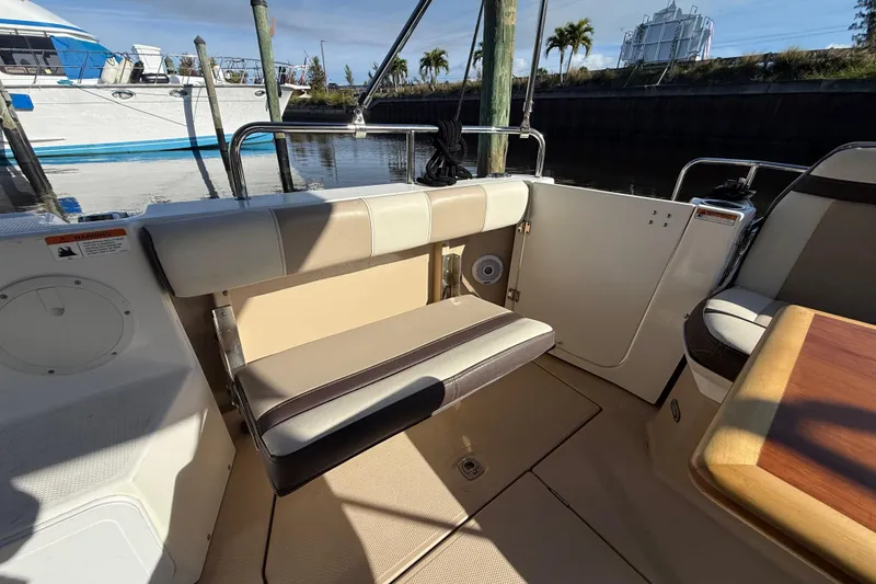 Slide: The Image of 2015 Cutwater 28 boat interior with seating and table, docked near other boats. - 9