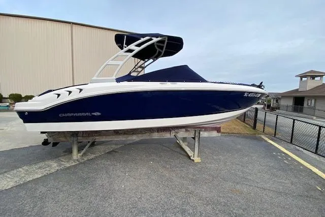 Slide: The Image of 2023 Chaparral 210 SSi boat with blue hull and white trim on display outdoors. - 19