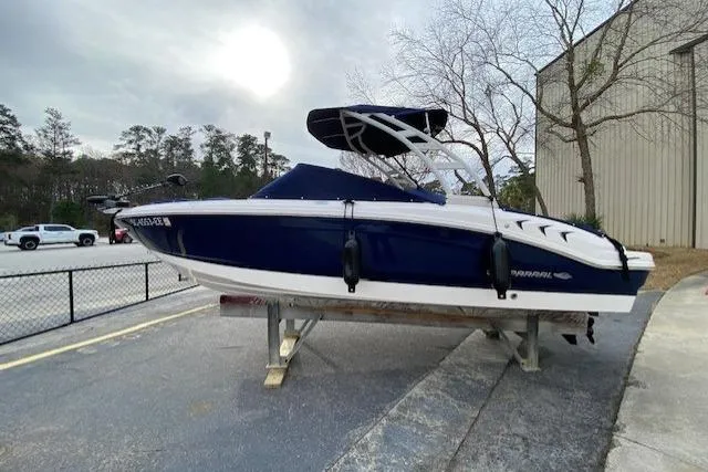 Slide: The Image of 2023 Chaparral 210 SSi boat on trailer, blue and white design, parked outdoors. - 20