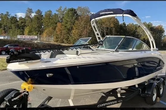Slide: The Image of 2023 Chaparral 210 SSi boat on trailer, blue and white, parked outdoors. - 21